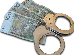 Na zdjęciu kajdanki i banknoty.