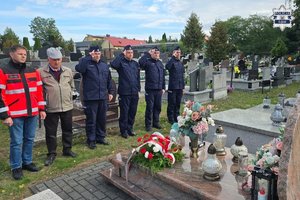 Naczelnik Wydziału Doboru i Szkolenia Komendy Wojewódzkiej Policji w Katowicach, wspólnie z Komendantem Powiatowym Policji w Będzinie, Pierwszym Zastępcą Komendanta Powiatowego Policji w Zawierciu i umundurowanym policjantem oddają honor poległemu sierż. Grzegorzowi Załodze. Na zdjęciu również ojcem poległego policjanta oraz przedstawiciel pogotowia ratunkowego.