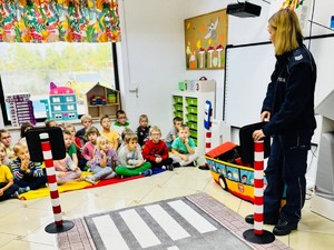 Na zdjęciu policjantka prowadzi prelekcje dla grupy przedszkolaków.