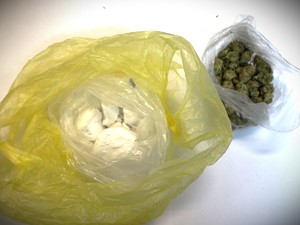 Na zdjęciu biały proszek w reklamówce i zielony susz w worku.