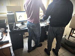 Na zdjęciu technik kryminalistyki pobiera podejrzanemu odciski palców.