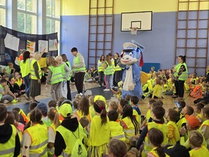 Zdjęcie z grupą uczniów i nauczycieli podczas mody odblaskowej na sali gimnastycznej.
