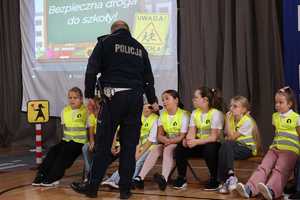 Na zdjęciu policjant ruchu drogowego pyta uczniów podczas prowadzonych zajęć.