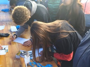 Na zdjęciu uczniowie wypełniający zgłoszenia do biegu