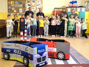 Zdjęcie grupowe policjantów i grupy uczniów, którzy trzymają w ręce odblaski.