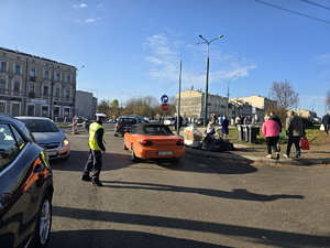 Na zdjęciu policjant ruchu drogowego kieruje ruchem przy skrzyżowaniu.