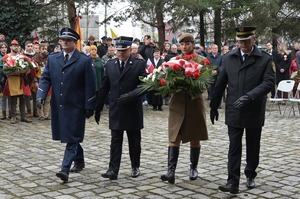 Na zdjęciu przedstawiciele służb mundurowych maszerują aby złożyć kwiaty.