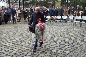Na zdjęciu poseł na sejm składa kwiaty.