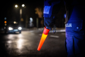 Na zdjęciu widzimy zbliżenie na latarkę policyjną trzymaną przez policjanta