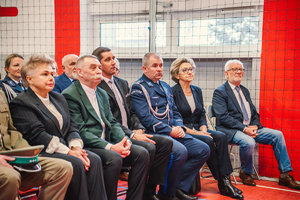 Na zdjęciu zaproszeni goście siedzący na sali gimnastycznej.