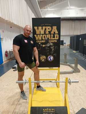 Na zdjęciu policjant stojący przy modlitewniku-przyrządu do unoszenia ramion ze sztangą.