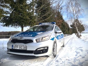 Na drodze radiowóz policyjny na zaśnieżonej drodze.