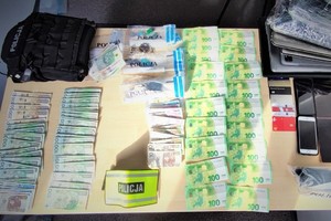 Na zdjęciu porozkładane przez policjantów zabezpieczone przedmioty: pieniądze i telefony.