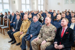 Zdjęcie grupowe przedstawiające zgromadzonych policjantów i zaproszonych gości w sali sesyjnej Starostwa Powiatowego w Będzinie.