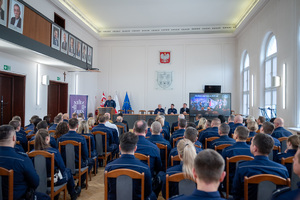 Zdjęcie grupowe przedstawiające zgromadzonych policjantów i zaproszonych gości w sali sesyjnej Starostwa Powiatowego w Będzinie z tylnej perspektywy.