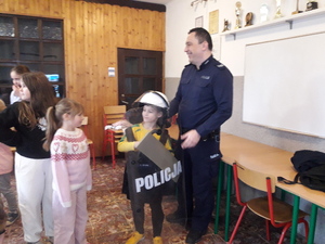 Na zdjęciu policjant z chłopcem przebranym za policjanta.