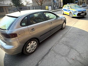 Na zdjęciu radiowóz policyjny i samochód osobowy na drodze.