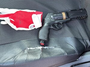 Na zdjęciu pistolet gazowy na siedzeniu w pojeździe.