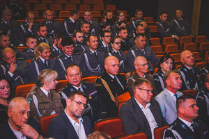 Zdjęcie grupowe w teatrze przedstawiające policjantów oraz gości na widowni.