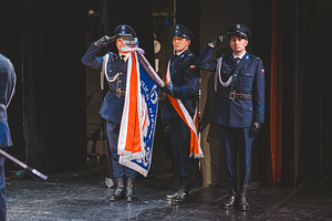 Zdjęcie przedstawiające sztandar Komendy Powiatowej Policji w Będzinie w teatrze.