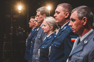 Zdjęcie grupowe w teatrze przedstawiające policjantów występujących do mianowania na scenie.