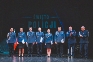 Zdjęcie grupowe w teatrze przedstawiające policjantów występujących do mianowania na scenie z Zastępcą Komendanta Wojewódzkiego Policji w Katowicach oraz Komendantem Powiatowym Policji w Będzinie.