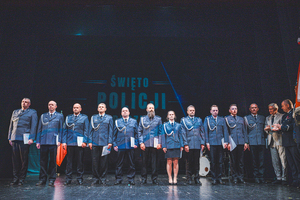 Zdjęcie grupowe w teatrze przedstawiające wyróżnionych policjantów na scenie z Komendantem Powiatowym Policji w Będzinie oraz Burmistrzem Miasta Czeladź.