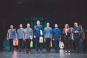 Zdjęcie grupowe w teatrze przedstawiające wyróżnionych policjantów na scenie z Komendantem Powiatowym Policji w Będzinie oraz Zastępcą Wójta Gminy Psary.
