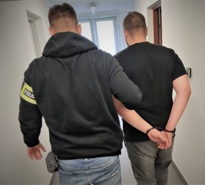 policjant prowadzi zatrzymanego
